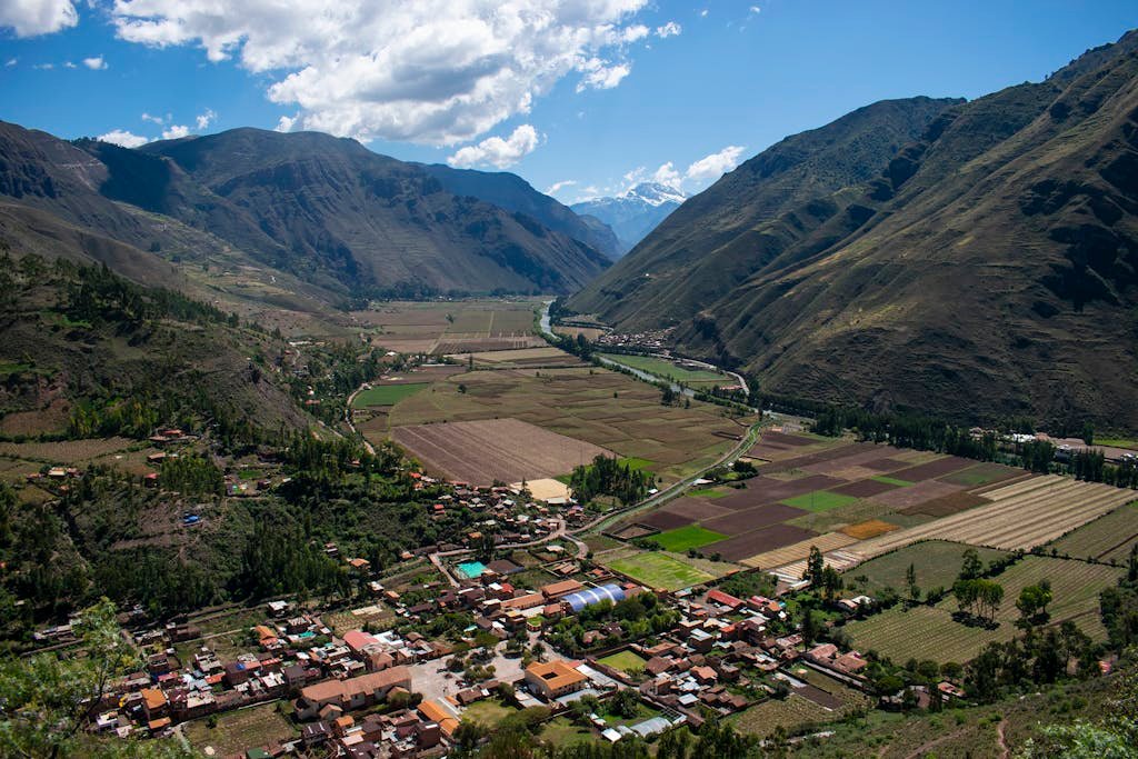 Breathtaking aerial view of Písac in the Sacred Valley, Perú, surrounded by mountains and farmland.