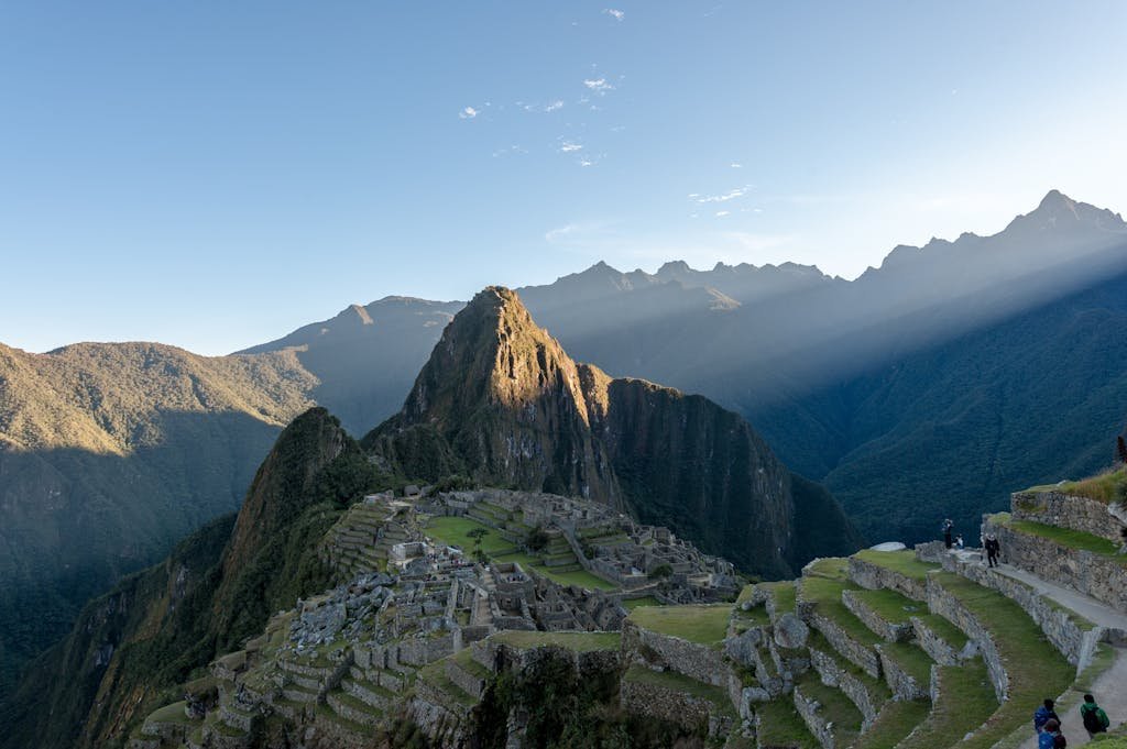 Dramatic aerial view of Machu Picchu with sunrays, capturing its ancient beauty and mountainous landscape.